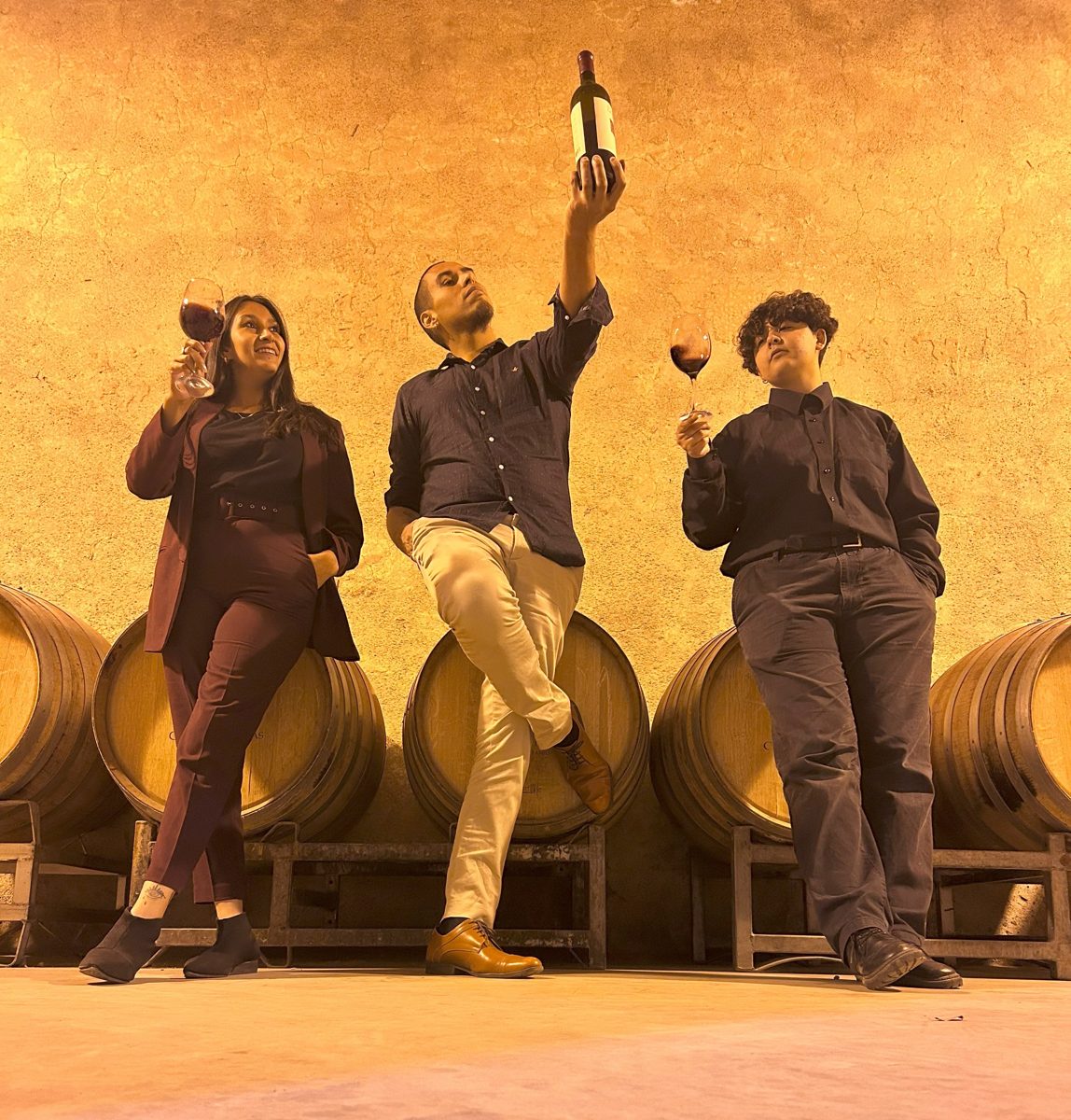 El equipo de Sin Etiquetas brindando con vino entre barricas en una bodega de Mendoza